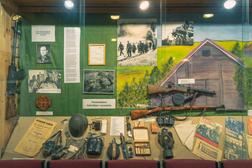 Näyttelyvitriini, jossa aseita ja muuta sotarekvisiittaa