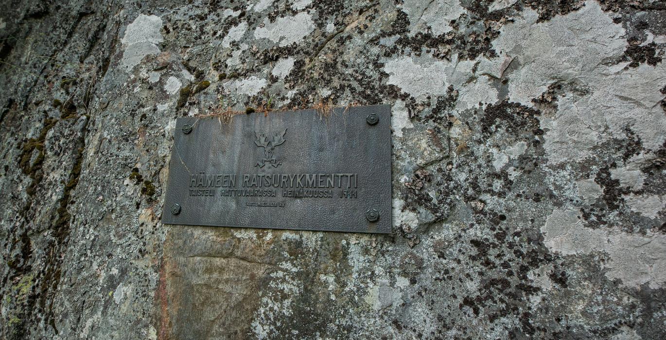 A plaque on a sheer rock wall at Hovattala commemorates the fight of H&auml;me Cavalry Regiment in Hattuvaara in July 1944. 